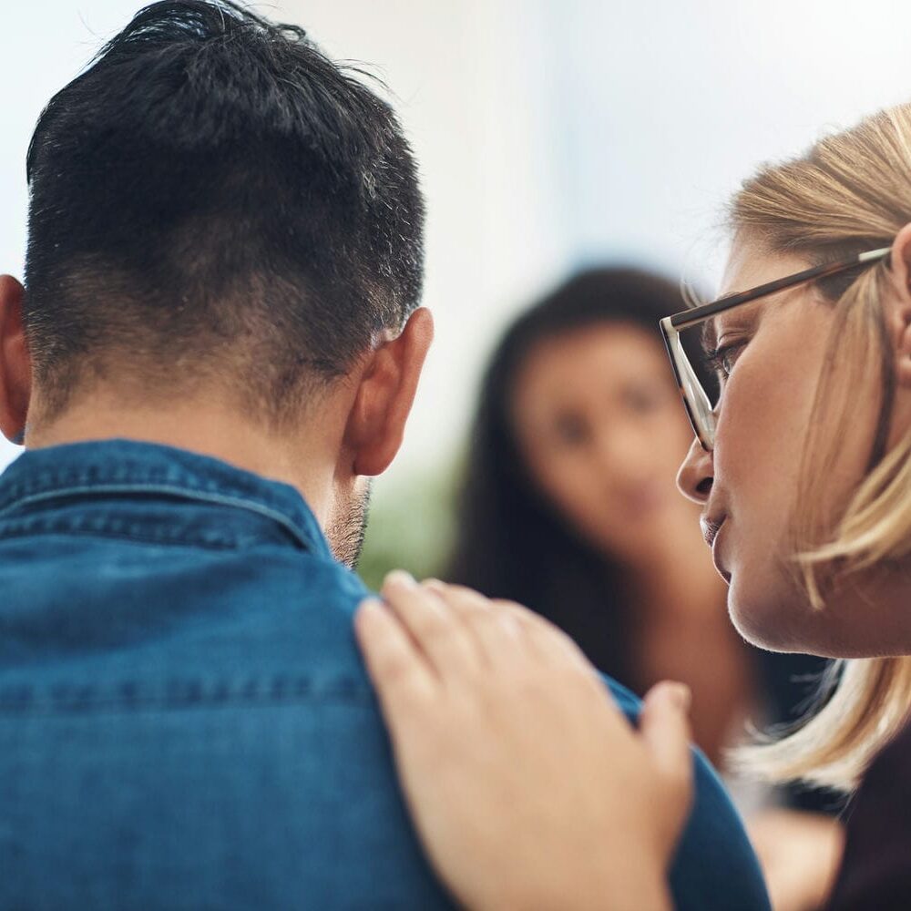 Wife consoling her grieving husband during a counselling session, representing the families supported through fatality and dependency claim analyses