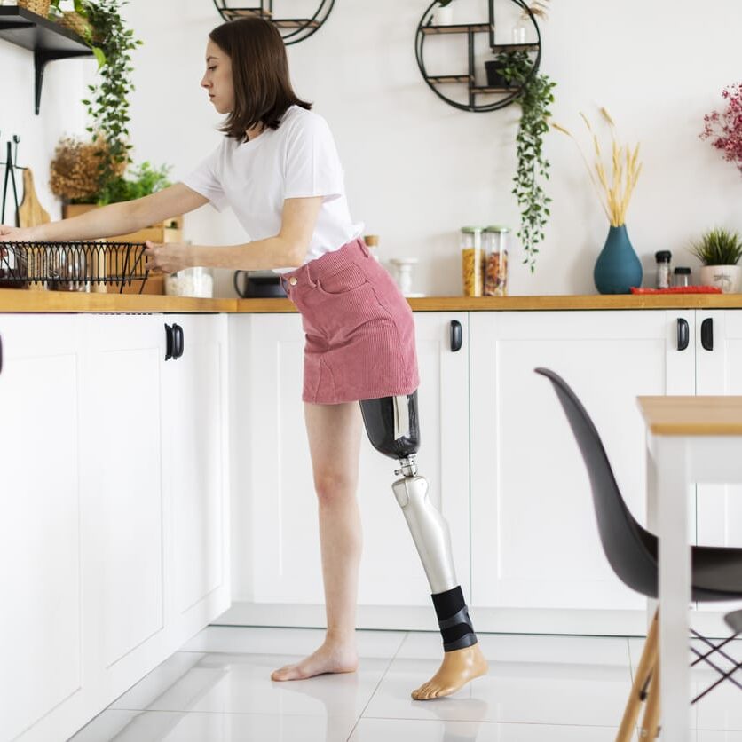 Woman with a prosthetic leg performing daily activities at home, illustrating long-term care needs